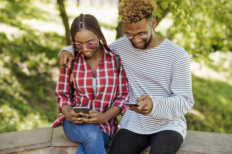 couple-noirs-avec-telephones-dans-le-parc